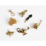 A selection of gold and yellow metal bracelet charms, to include a gold mounted jet coloured figa