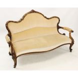 A Victorian walnut framed settee, the serpentine back carved with ribbon tied detail, above the