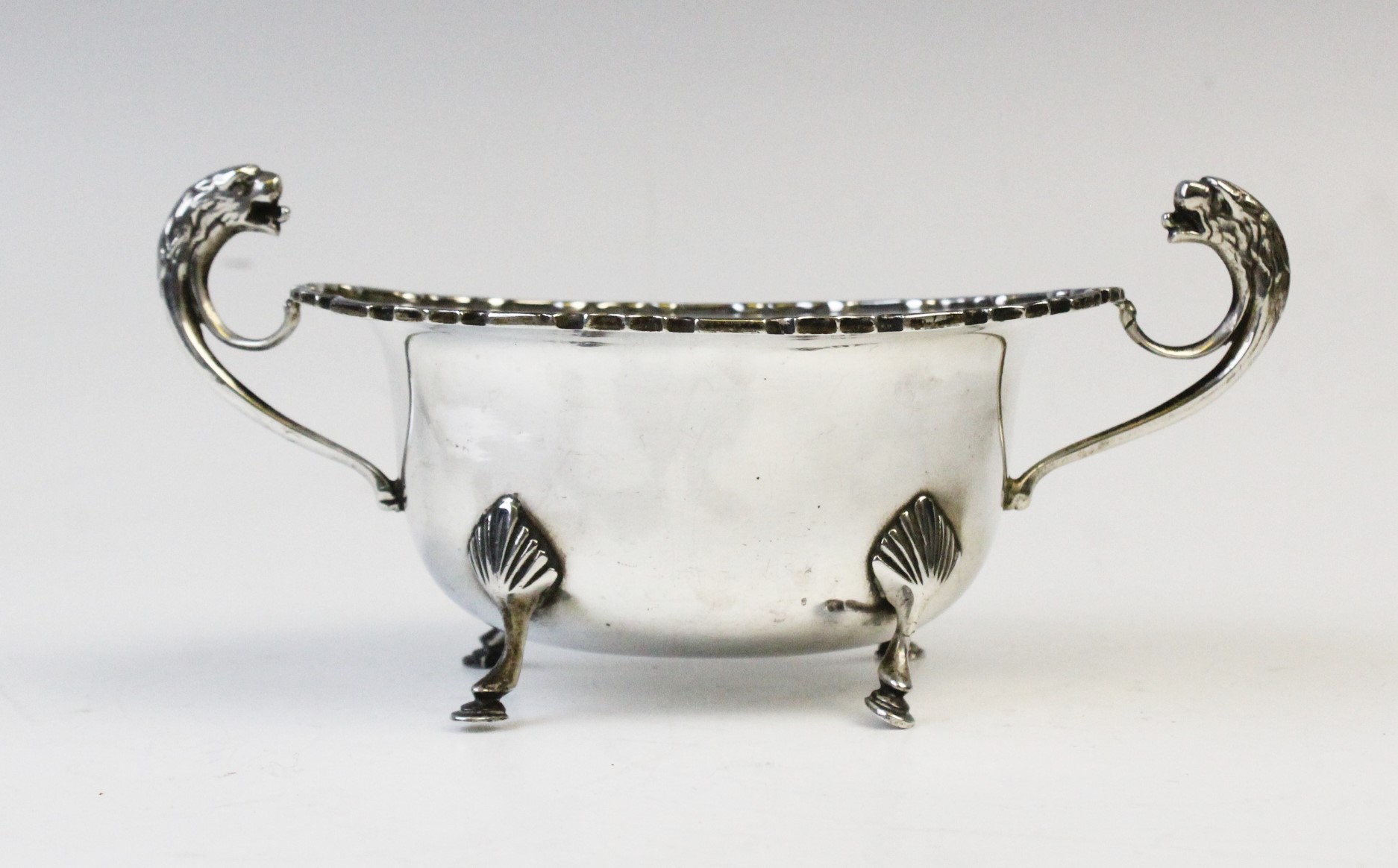 A George V twin-handled silver sugar bowl by E Hill, Birmingham 1934, of oval form with shaped