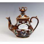 A Victorian Measham bargeware treacle glazed teapot and cover, late 19th century, the body applied