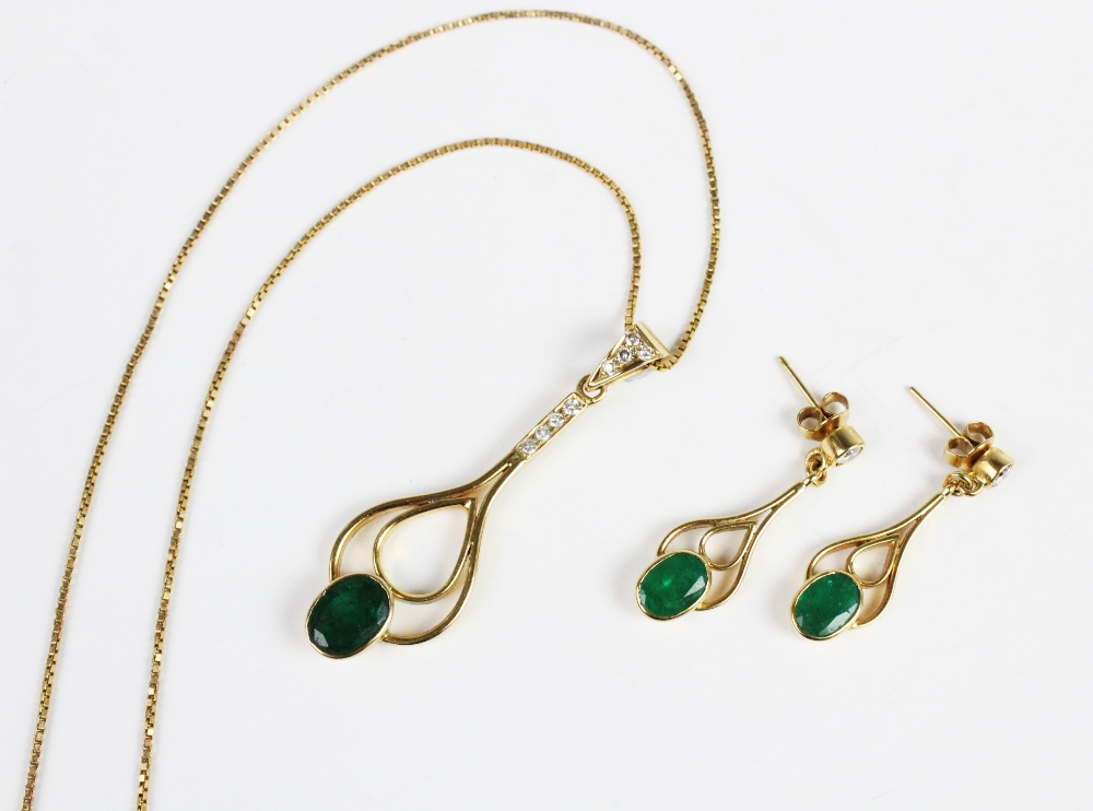 An emerald and diamond pendant and earring suite, the pendant comprising an oval mixed cut emerald