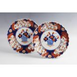 A pair of Japanese porcelain Imari decorated plates, each of circular scalloped form and decorated