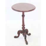 A mid 19th century mahogany lamp table, the circular top on a turned column and three leaf carved