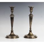 A pair of late 19th century white metal candlesticks, each with urn shaped sconces and detachable