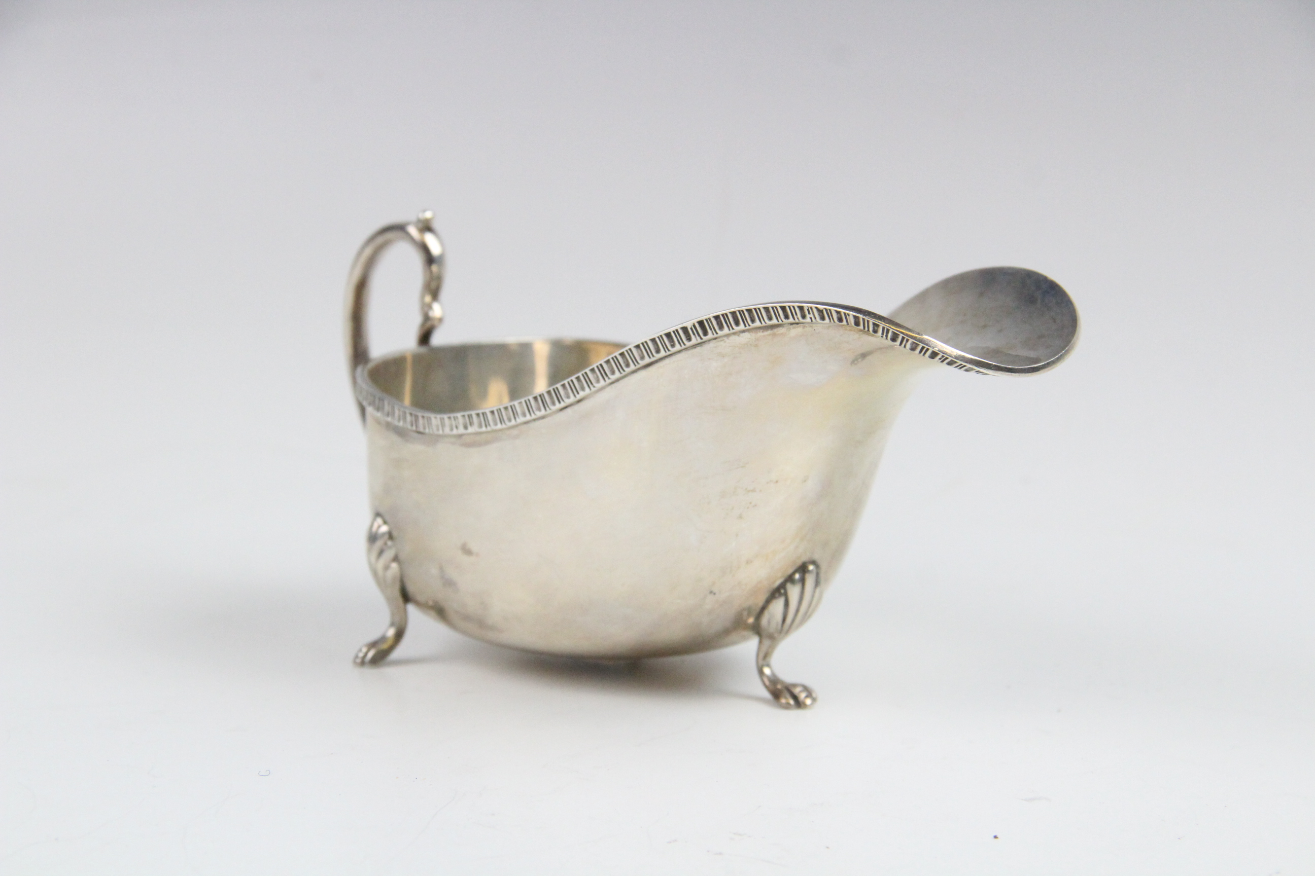 A silver sauce boat by Saunders & Mackenzie, Birmingham 1954, of typical form with gadroon rim and