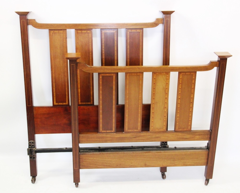 A pair of Edwardian mahogany slatted single beds, with satinwood crossbanded vertical rails,