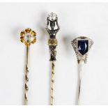 An early 20th century diamond set stick pin, fashion as a blackamoor holding a round old cut
