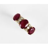 A ruby and diamond dress ring, comprising a central oval cut ruby measuring 8mm x 6mm, with a