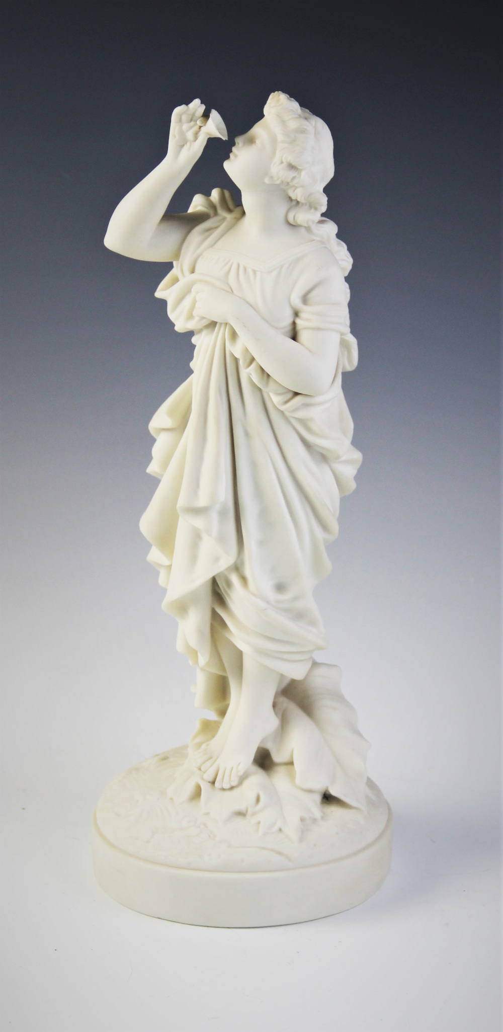 A Parian ware figure of a flower picker, modelled standing with her hand aloft smelling a flower, - Image 2 of 4