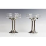 A pair of Art Deco tazzas, the shallow glass dishes with etched geometric motifs, raised on white