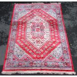 A Persian design silk work rug, the vibrant red ground with central graduated lozenges, within a