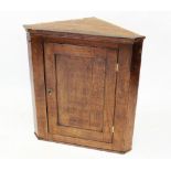 A George III oak straight front corner cupboard, the single panelled door opening to two shelves,