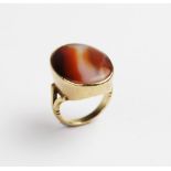 A carnelian set 9ct gold dress ring, the central polished carnelian cabochon measuring 24mm x