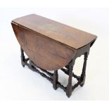 An early 18th century oak drop leaf table, the oval plank top above a shaped frieze, raised upon