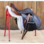 A Triumph leather saddle by Butler Brothers, Walsall, 8" wide, 17.5" seat, with sheepskin numnah,