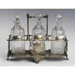 A three bottle tantalus, comprising three cut glass decanters, each 21cm high, each with a white