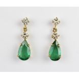 A pair of emerald and diamond drop earrings, each comprising two round brilliant cut diamonds, (each