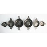 A set of four pewter porringers, probably 18th century, comprising: two small single handled