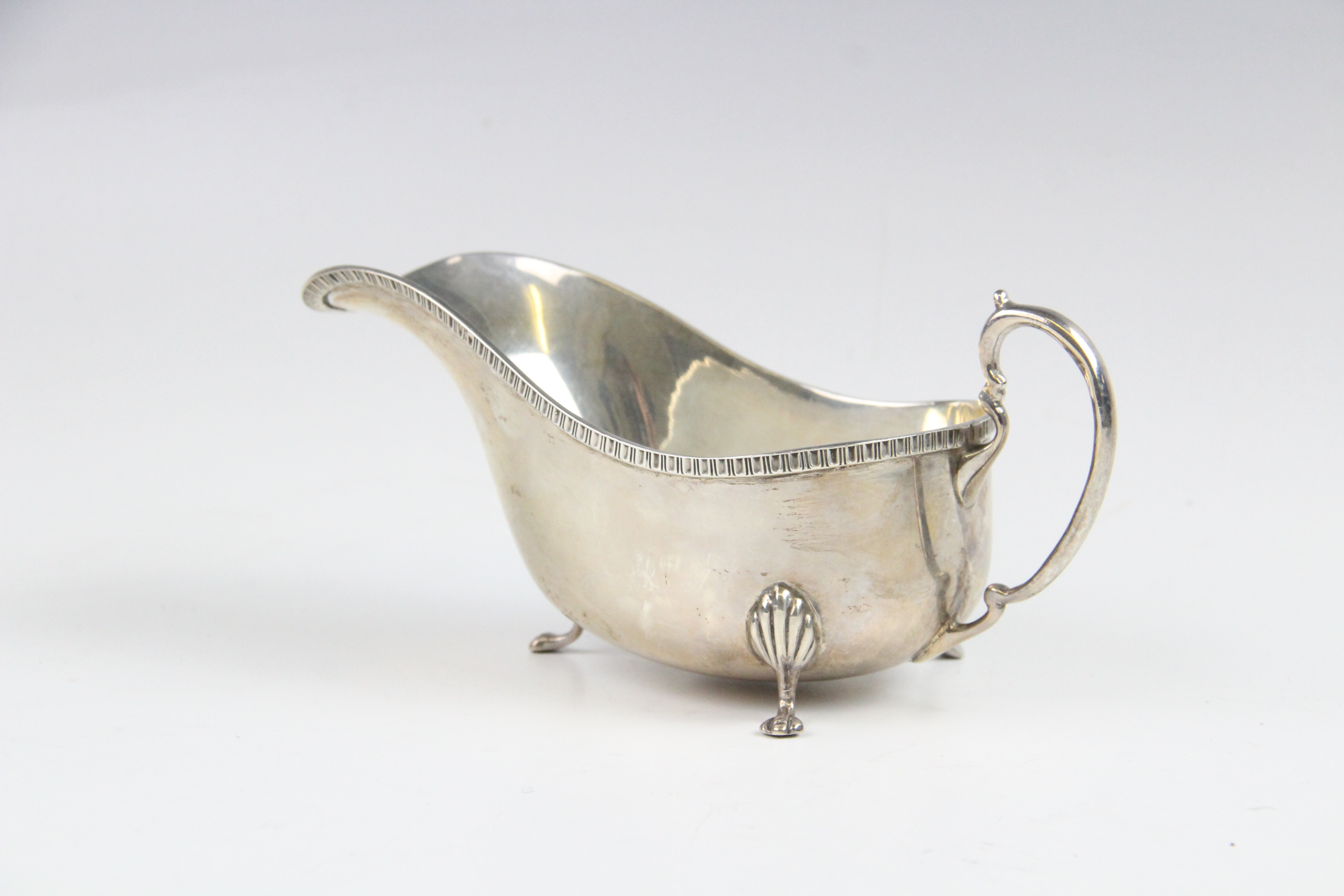 A silver sauce boat by Saunders & Mackenzie, Birmingham 1954, of typical form with gadroon rim and - Image 2 of 4