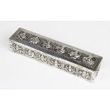 A Burmese white metal box of rectangular form with embossed decorative panels to cover and sides