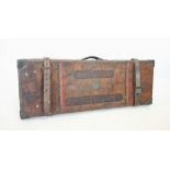 An Adams & Co leather double gun case, of typical form with leather over-straps and central sprung