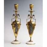 A pair of early 20th century brass candlesticks, each of classical vase form and with applied