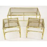 A mid 20th century gilt metal and smoked glass nest of three tables, the rectangular glass tops