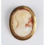 A carved shell cameo brooch pendant, the central carved cameo depicting the profile of a woman,