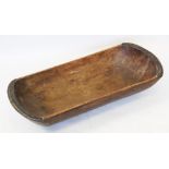 A 19th century carved fruit wood dough trough, of pill form with metal reinforced ends, 78cm long