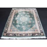 A Chinese embossed wool rug, the central foliate medallion on an olive green ground, enclosed by