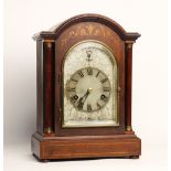An Edwardian mahogany cased bracket clock, the arched case with tapering pilasters flanking the 13cm