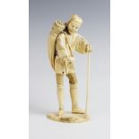 A Japanese signed ivory okimono, Meiji period (1868-1912), modelled as a field worker with a sheaf
