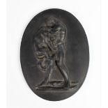 A Wedgwood black basalt oval plaque, 19th century, depicting Hercules strangling the Nemean Lion,
