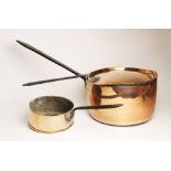 A large copper saucepan and cover, 19th century, with wrought iron handles and a smaller similar