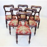 A set of six Victorian mahogany buckle back dining chairs, the rail back with carved scroll