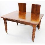 An early 20th century golden oak extending dining table, the rectangular top with moulded and