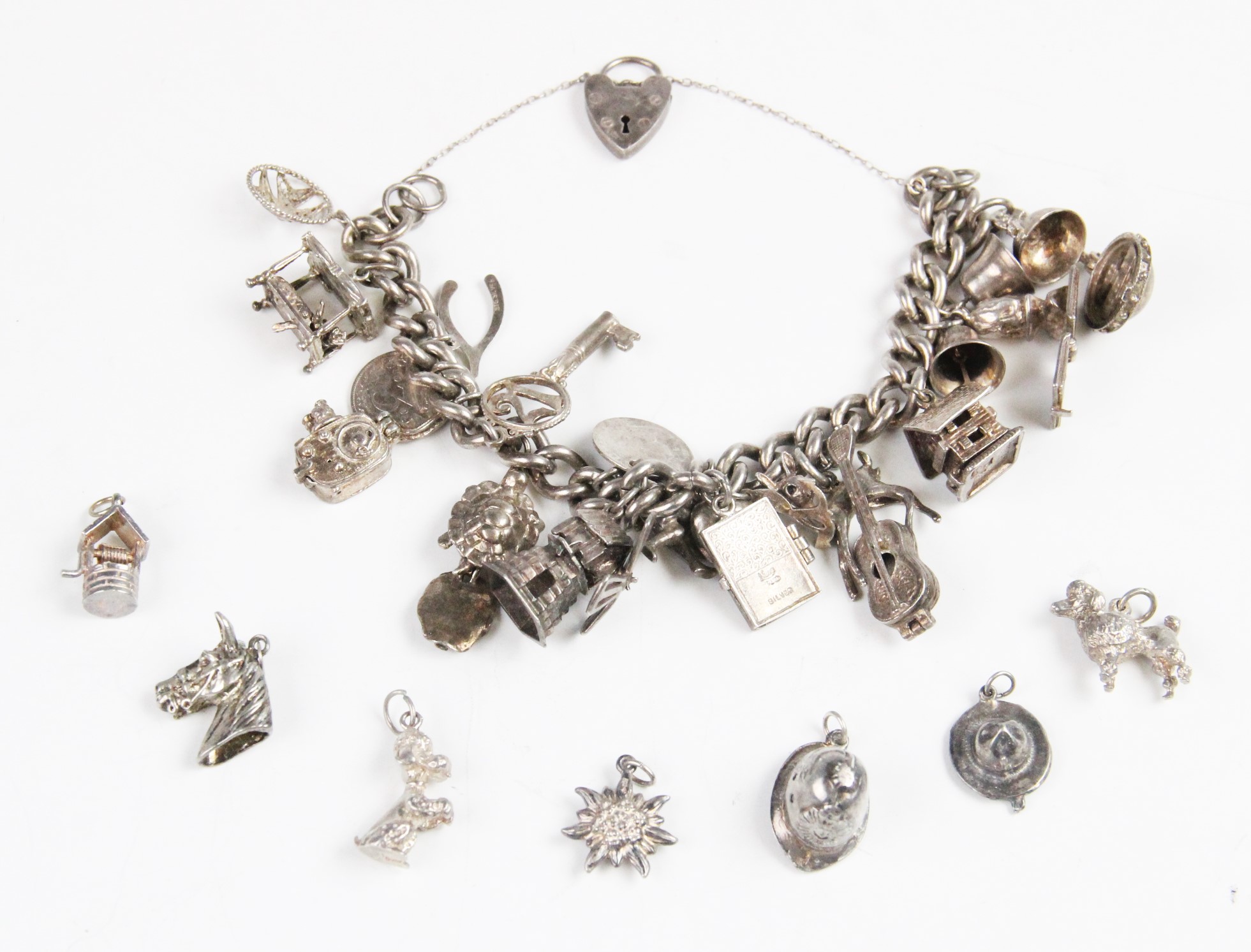 A silver charm bracelet with assorted silver and white metal charms,