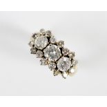 A diamond cluster ring, comprising a central round brilliant cut diamond weighing approx. 0.75