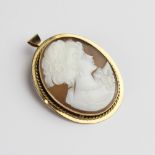 A 9ct gold carved shell cameo brooch/pendant, the oval cameo depicting a lady in formal attire