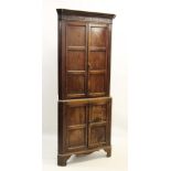 A George III oak freestanding corner cupboard, the moulded cornice above a frieze inlaid with