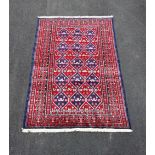 A Turkman rug, with a unique all over design against a red and blue ground, 195cm x 130cm