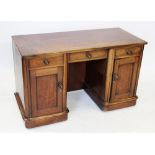 A Victorian mahogany kneehole desk/dressing table, the cleated rectangular top above an inverted