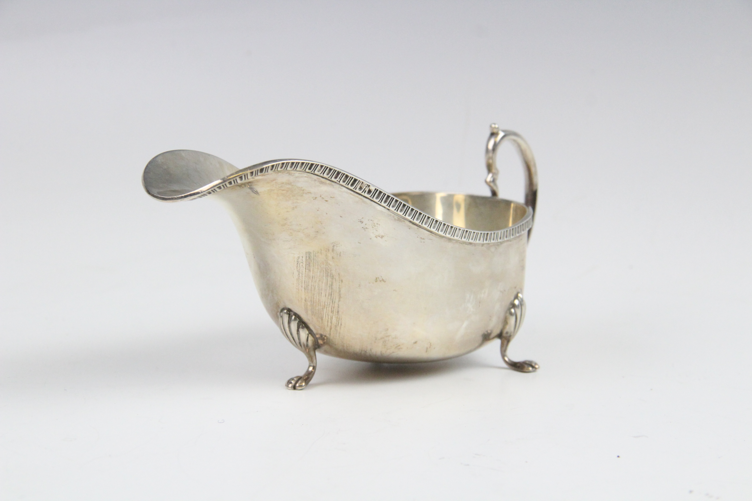 A silver sauce boat by Saunders & Mackenzie, Birmingham 1954, of typical form with gadroon rim and - Image 3 of 4