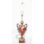 A rouge marble effect lamp base, modelled as a two handled pedestal urn, with snake twist handles,
