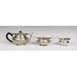 A Victorian three-piece silver tea service by Walker & Hall, Sheffield 1899, comprising teapot, milk