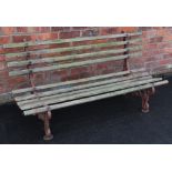 A 19th century cast iron and hardwood garden bench, the pair of cast iron interlaced openwork