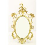 A late 19th/early 20th century French Rococo style gilt wood wall mirror, the oval mirror plate