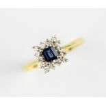 A sapphire and diamond cluster ring, the central rectangular stepped cut sapphire (measuring 3.4mm x