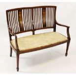 An Edwardian inlaid mahogany two-seater settee, with a pair of inlaid splats above an upholstered