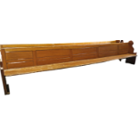 A very large late 19th/early 20th century scumbled/painted pitch pine pew, raised on standard